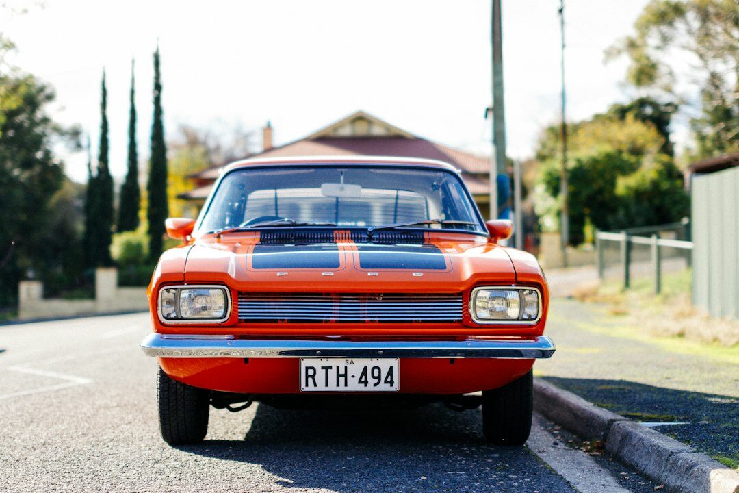 1970s muscle car with bold stripes displayed at a vintage automobile gathering