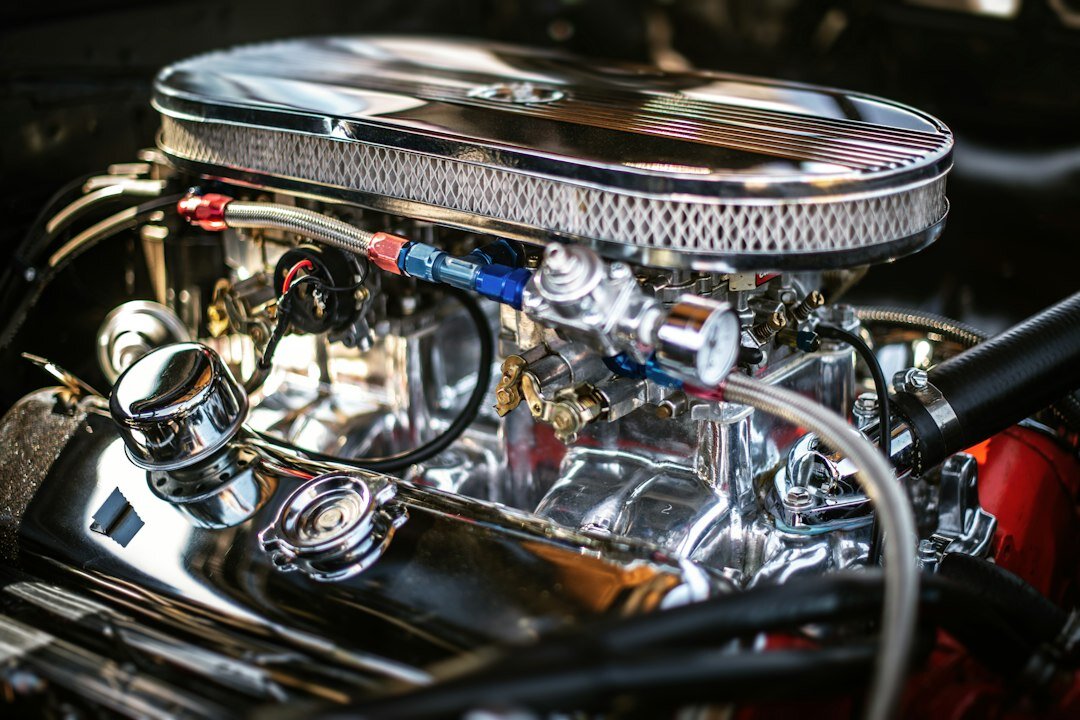 Close up of a polished vintage automobile engine bay with chrome carburetors