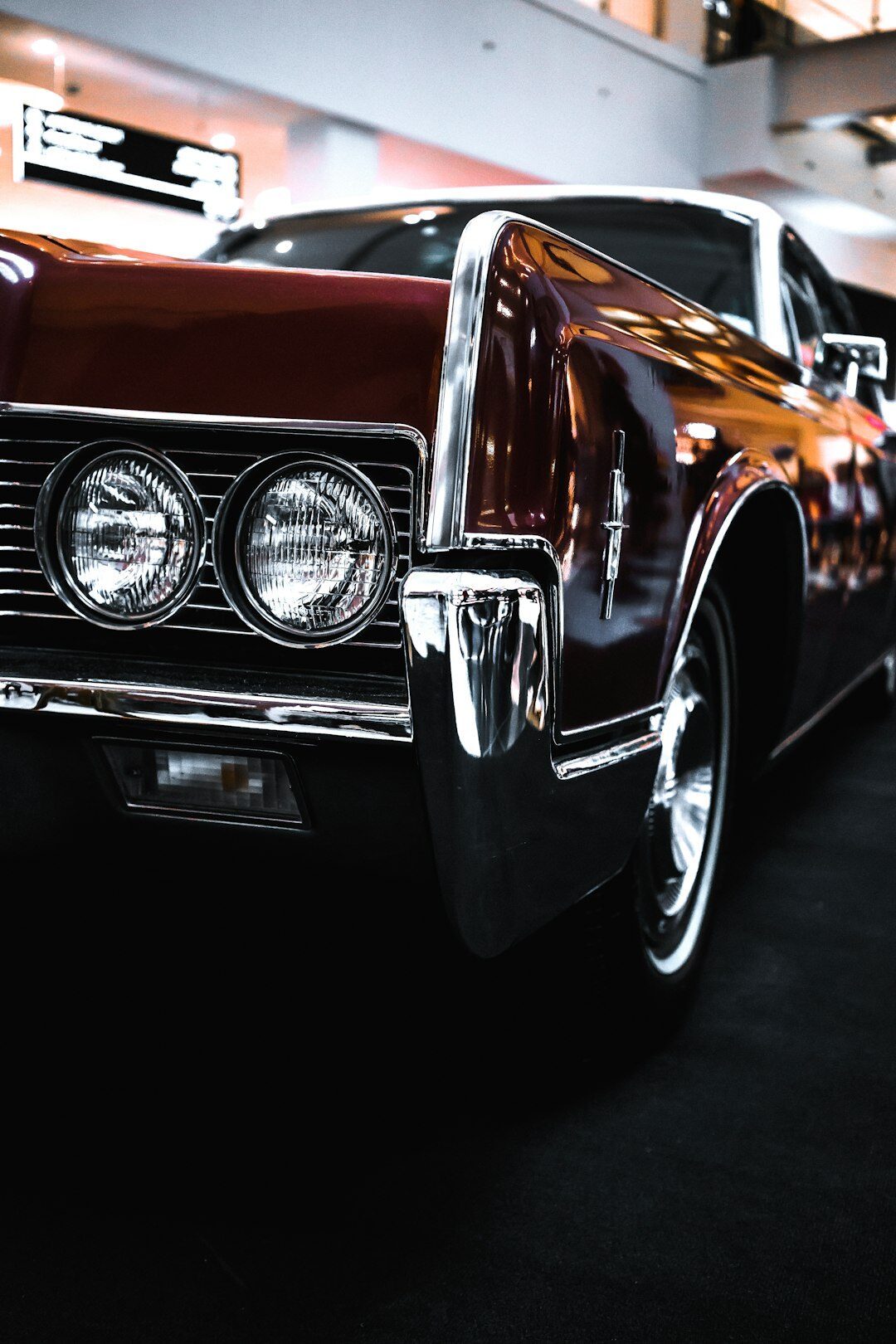 Elegant auction hall with a rare vintage automobile displayed under spotlights