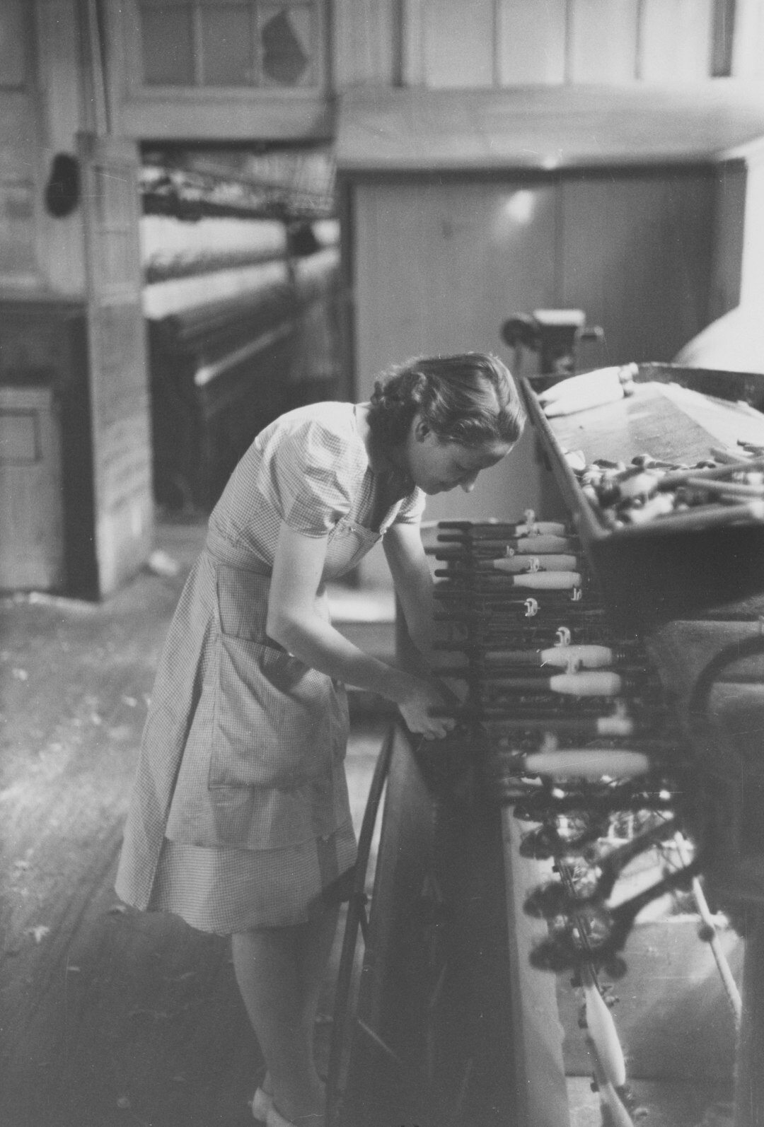 Editor examining vintage automobile photographs inside a wood-panelled archive room
